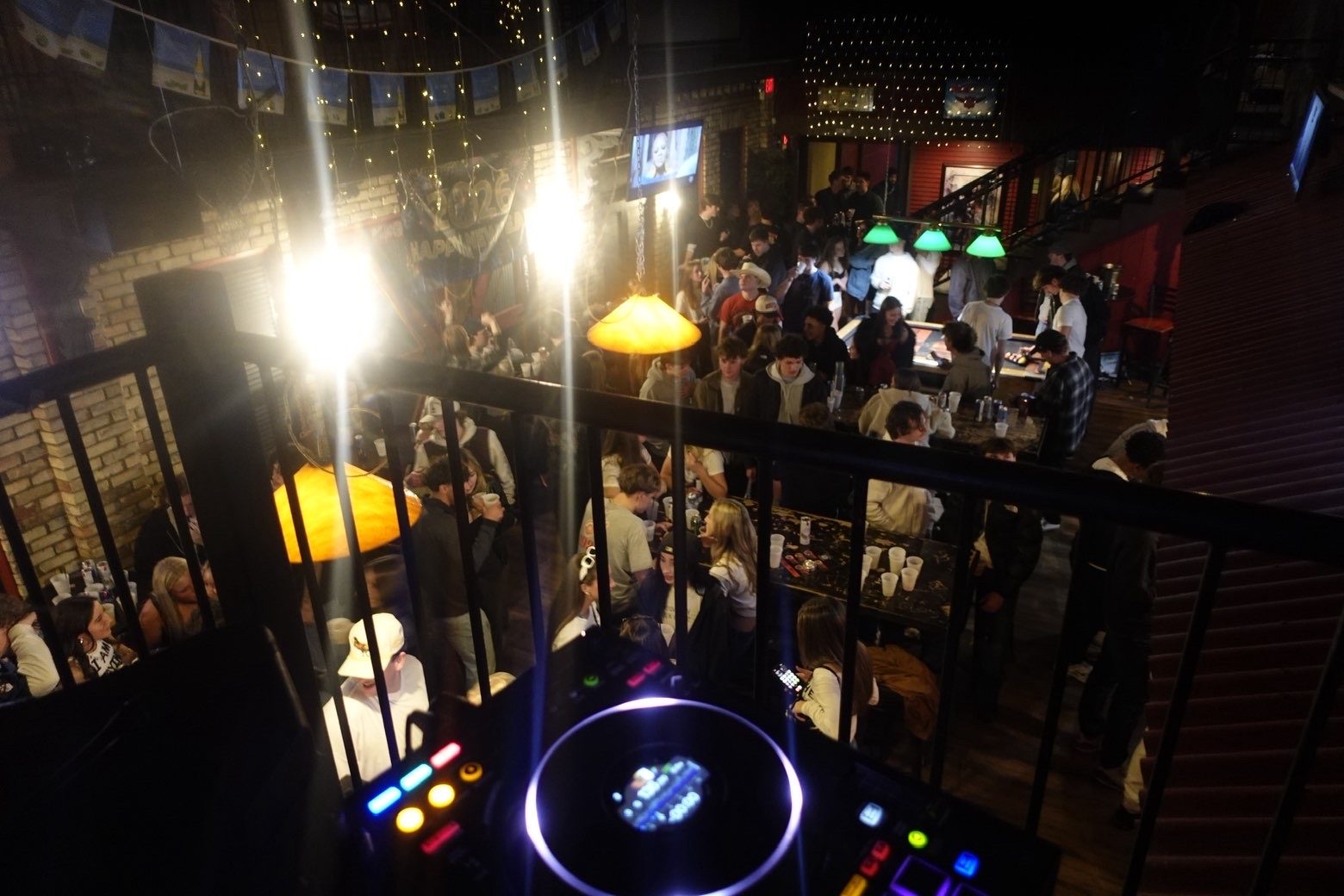 A packed venue seen from the DJ booth